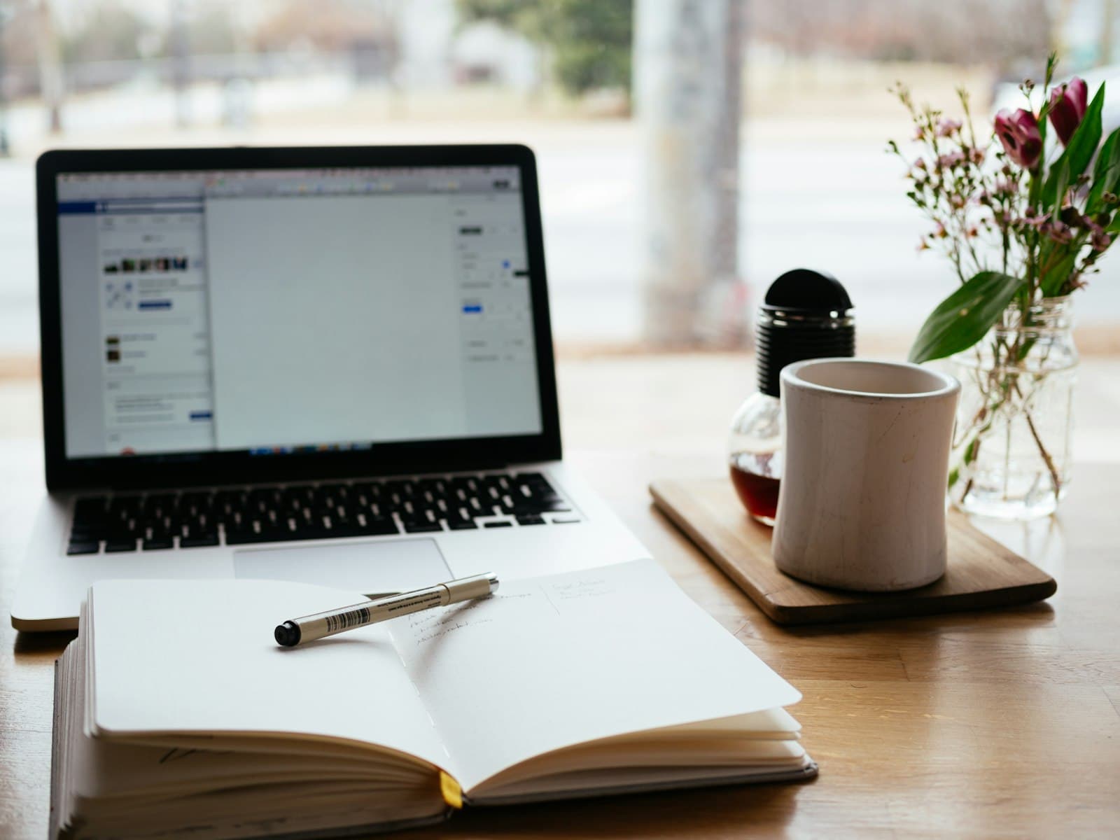 Open notebook and pen next to a laptop, ready for study notes